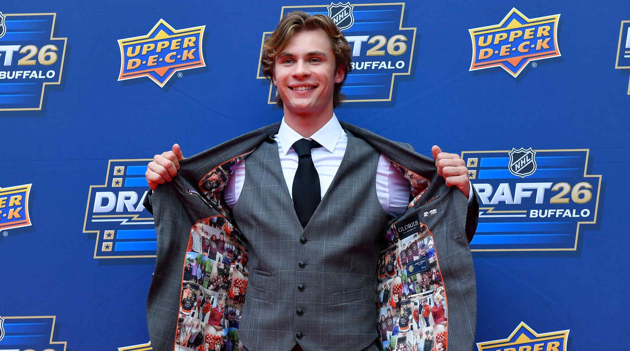 An image of Gavin McKenna showing off the inside of his suit jacket which has photos embroidered on the inside.